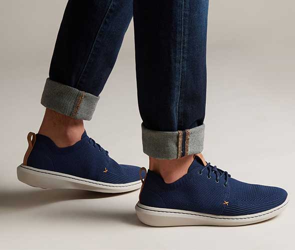 Closeup of casual sneakers with cuffed jeans